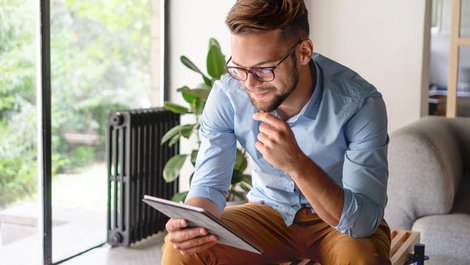 unseriöse Umzugsunternehmen, Mann sitzt mit Tablet in der Hand auf einer Bank, Foto: Stock Rocket / stock.adobe.com