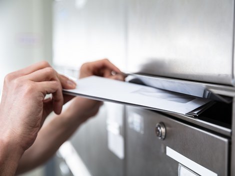 Miete mindern, Miete kürzen, Mietminderung, Mängelanzeige, eine Hand wirft einen Brief in einen Briefkasten, Foto: Andrey Popov/stock.adobe.com
