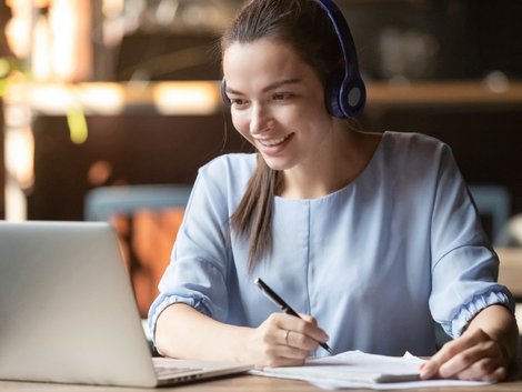 Immobilienmakler werden, junge Frau macht sich Notizen während sie auf einen Laptop-Bildschirm schaut. Foto: fizkes/stock.adobe.com