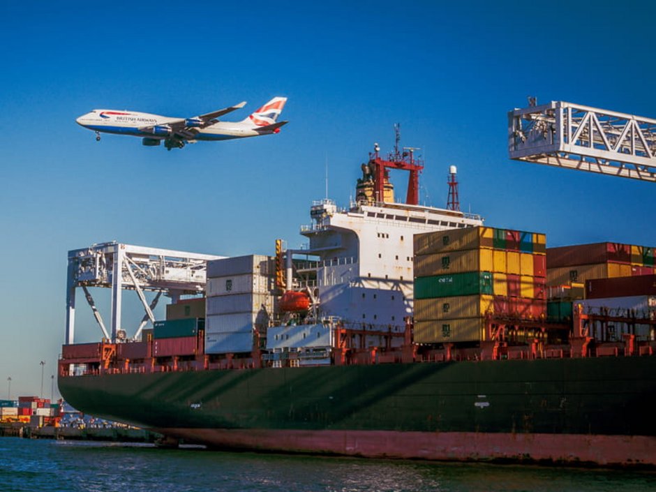 Auswandern Australien, Ein Containerschiff liegt in einem Hafen vor Anker, Foto: unsplash.com/vanveenjf