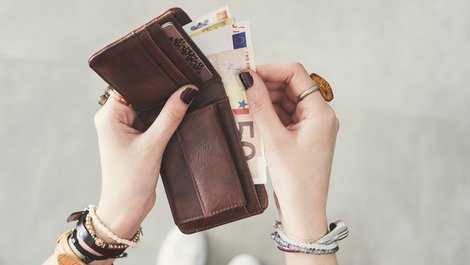 Fallen im Mietvertrag, eine Frau holt einen 50-Euro-Schein aus einem Portemonnaie, Foto: sebra / stock.adobe.com