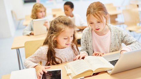 Stadtflucht, Grundschüler lernen mit Buch und Laptop, Foto: Robert Kneschke / stock.adobe.com