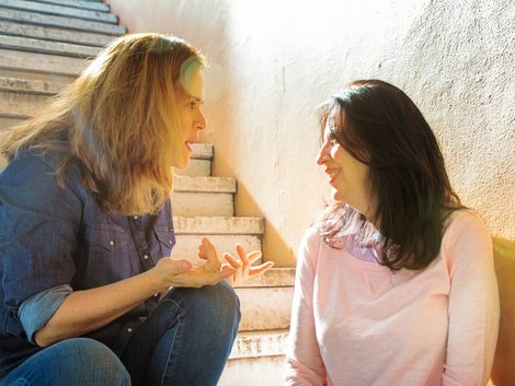 Diskriminierung auf dem Wohnungsmarkt, zwei Frauen sitzen im Treppenhaus und unterhalten sich, Foto: iStock.com/NicolasMcComber