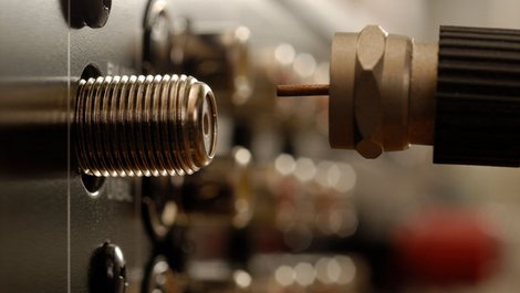 Ein Sat-Kabel wird aus de Buchse gezogen, Foto: istock.com / KLH49