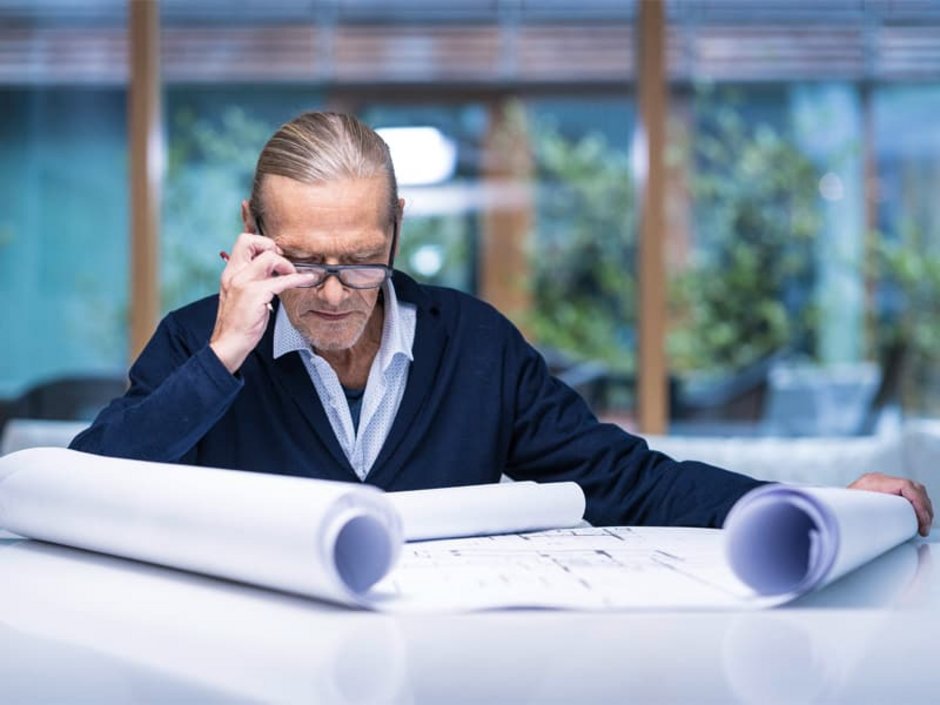 Liegenschaftskataster, Mann begutachtet Unterlagen zur Baugenehmigung, Foto: iStock/RepicturingHomeless