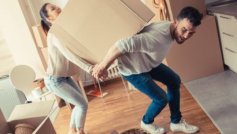 Umzugskartons packen, Paar schleppt gemeinsam Umzugskarton, Umzugskarton zu schwer, Foto: BalanceFormCreative / stock.adobe.com
