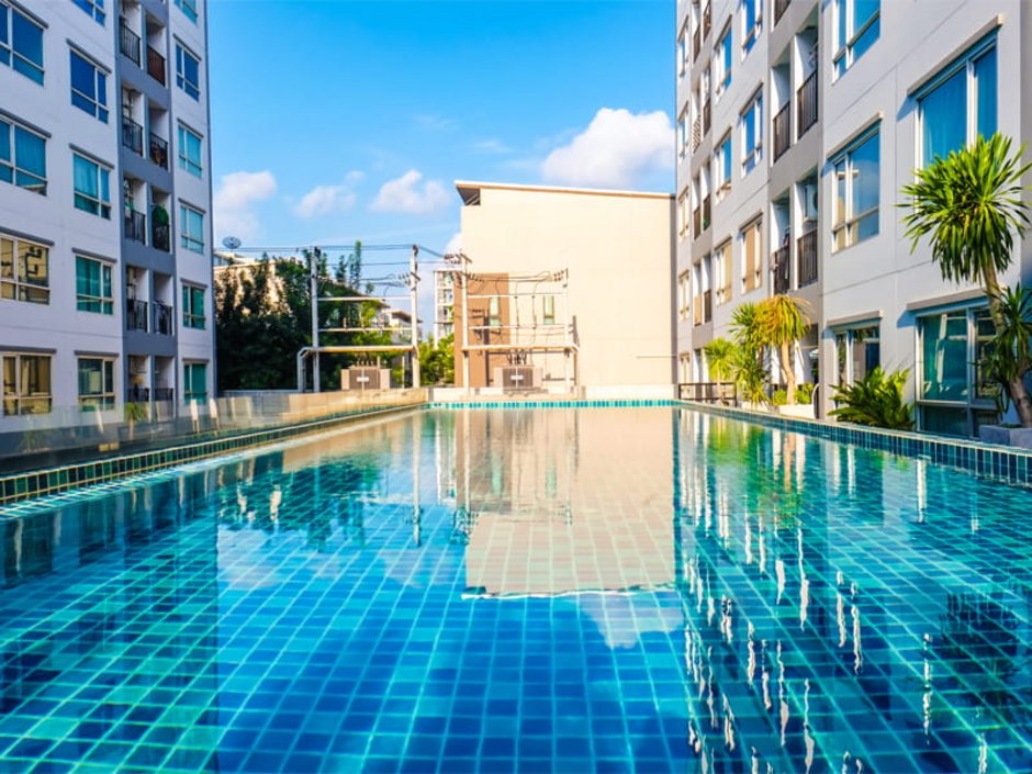 Auswandern nach Thailand, Wohnungen in zwei sich gegenüberstehenden Gebäudekomplexen. In der Mitte ist ein Pool, Foto: themorningglory/stock.adobe.com