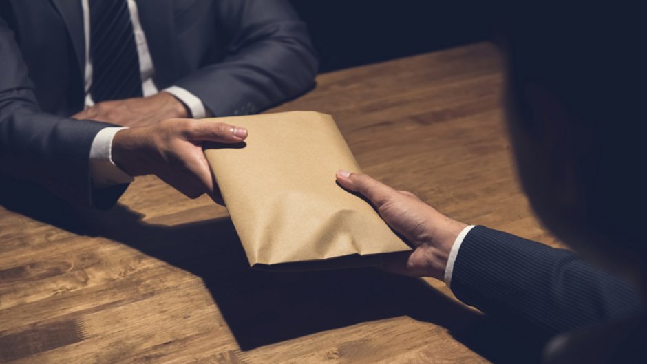 Geldwäschegesetz, Übergabe von einem Umschlag mit Bargeld, Foto: istock.com / Kritchanut