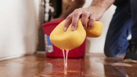 Zweitschlüssel, Mann beseitigt Wasserschaden mit einem Schwamm, Foto: Monkey Business / stock.adobe.com