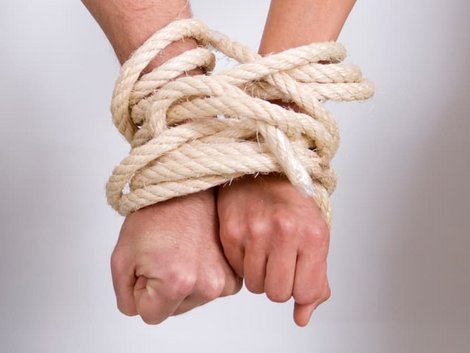 Immobilie geerbt, Erbengemeinschaft, Frau und Mann sind mit einem Seil an den Handgelenken gefesselt, Foto: iStock/Cirilopoeta