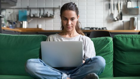 Genossenschaftswohnung, Frau sitzt auf grünem Sofa, Genosse werden, Genossenschaft beitreten Foto: fizkes / stock.adobe.com