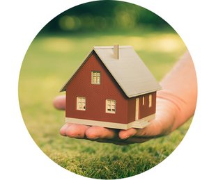 Bausparen, Baufinanzierung, Immobilie sofort finanzieren, eine Hand hält ein Modellhaus vor einer Wiese, Foto: Fokussiert/stock.adobe.com