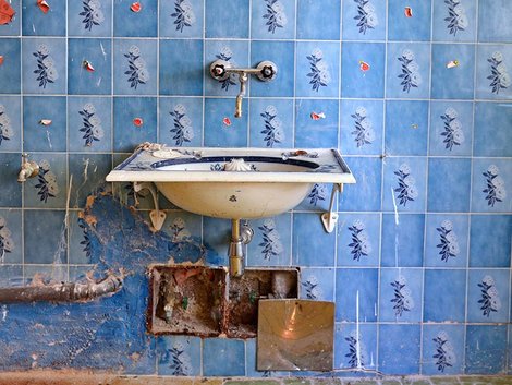 Renovierungskosten, Renovierungsfalle Hauskauf, Wasserleitungen, ein altes Waschbecken mit blauen Fliesen an der Wand, Foto: photo 5000/stock.adobe.com