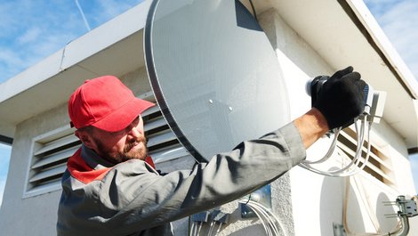 Satellitenschüssel, Profi montiert Satellitenschüssel, Foto: Kadmi / stock.adobe.com