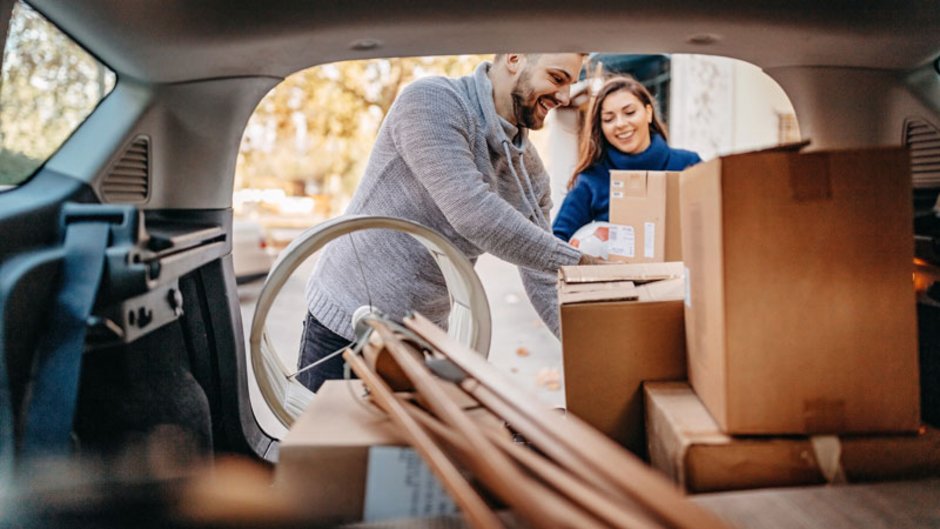 Transportversicherung, junges Paar packt Umzugkartons und Möbel ins Auto, Foto: iStock.com / StefaNikolic